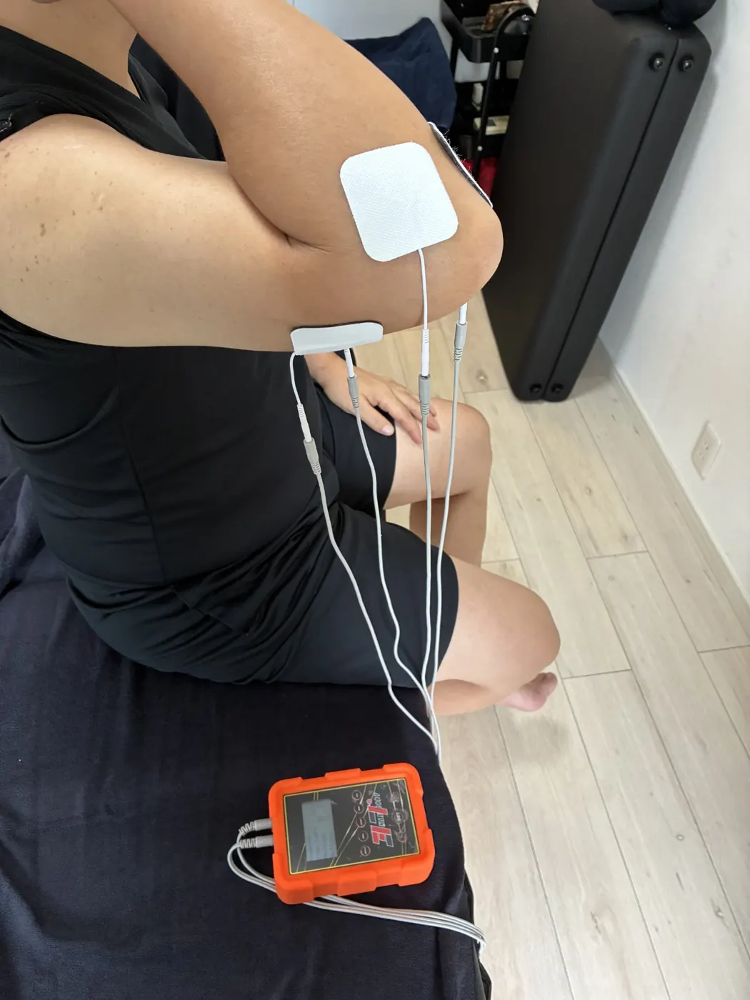 肘を曲げた姿勢で腕の周囲に電極パッドを配置した様子