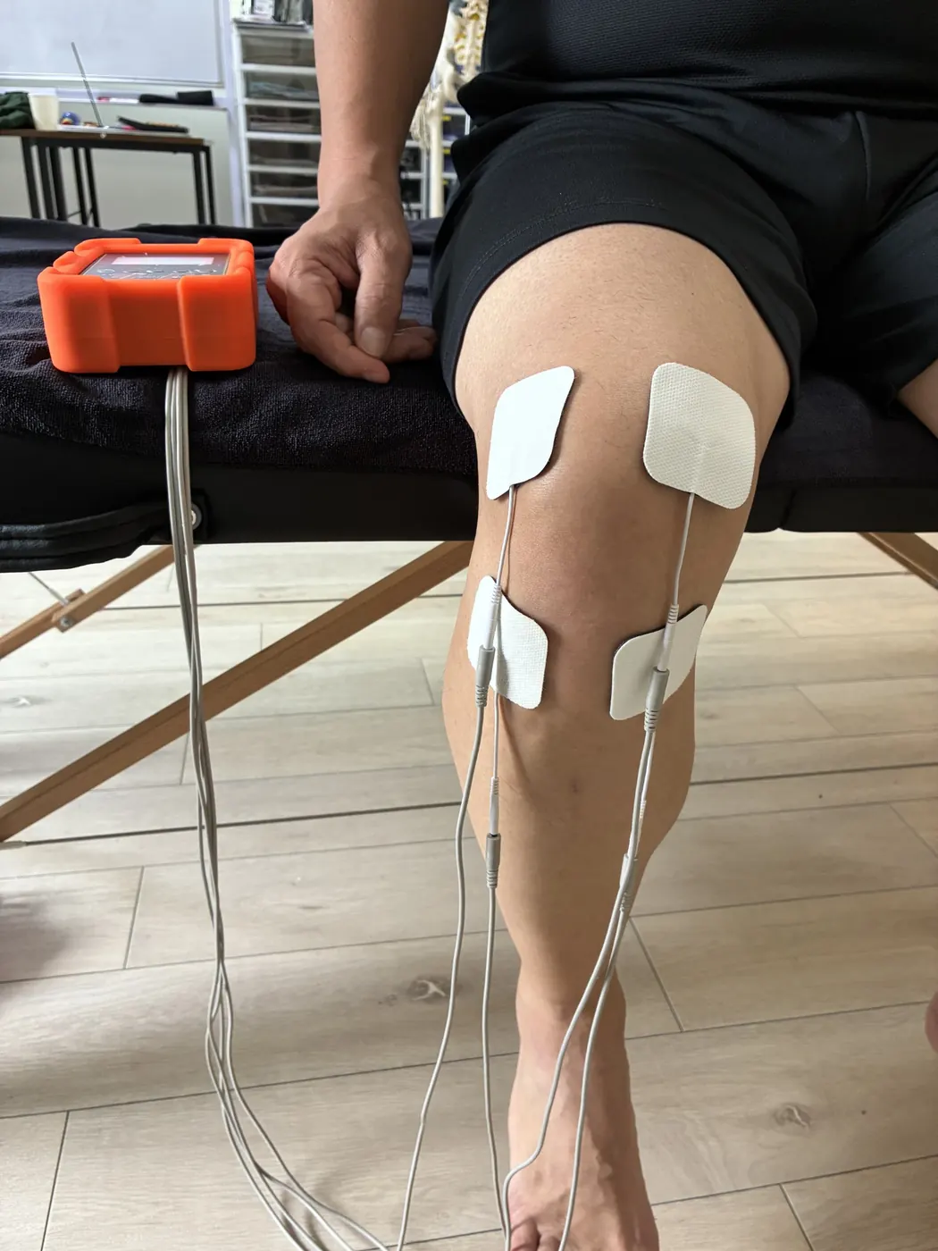 膝周辺にMAXBODYの電極パッドを貼り、施術準備を行っている様子